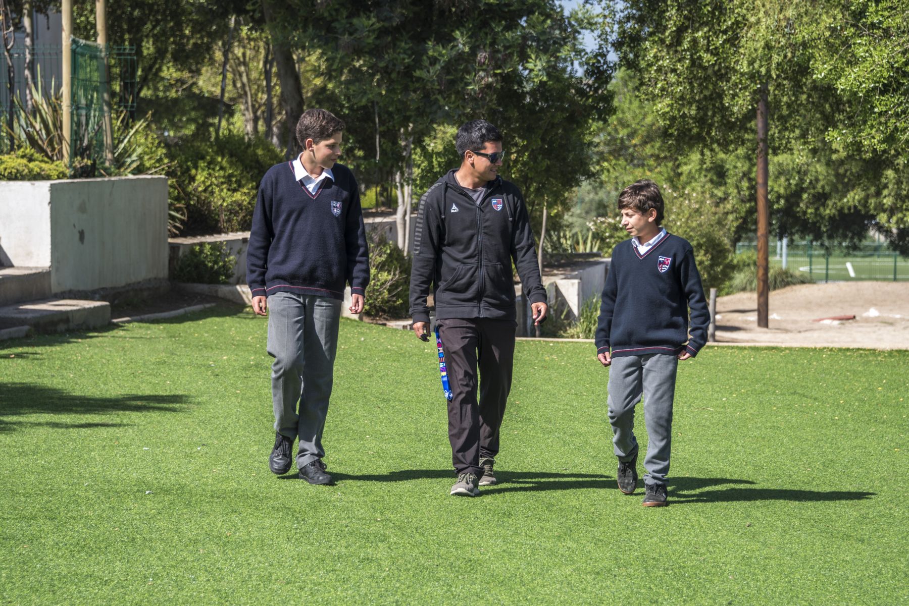Alumnos del Colegio Montemar caminando por la cancha de pasto sintético